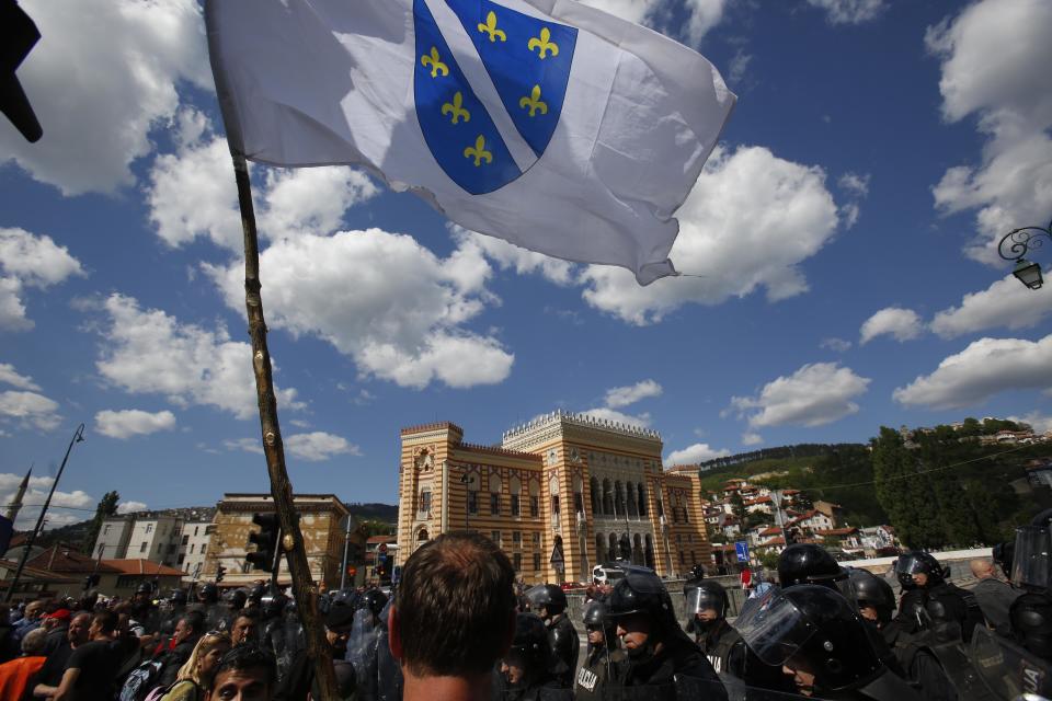 Bosnian people protest in front of a police cordon during a protest in the Bosnian capital of Sarajevo on Friday, May 9, 2014. A few hundred people from different parts of Bosnia have been protesting in Sarajevo over the high unemployment rate in the country and alleged government corruption. Protesters walked to the Sarajevo Library - a landmark destroyed during the Bosnian war - which is to be officially reopened today after reconstruction that has taken 18 years at the cost of over 16 million euros. They said they will continue the protest during the official ceremony to reopen the 19th century pseudo-Moorish construction that is expected to be attended by all top government officials as well as numerous international dignitaries. (AP Photo/Amel Emric)