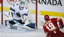 San Jose Sharks goalie Adin Hill makes a save on Calgary Flames' Matthew Tkachuk during the second period of an NHL hockey game, Tuesday, Nov. 9, 2021 in Calgary, Alberta. (Jeff McIntosh/The Canadian Press via AP)