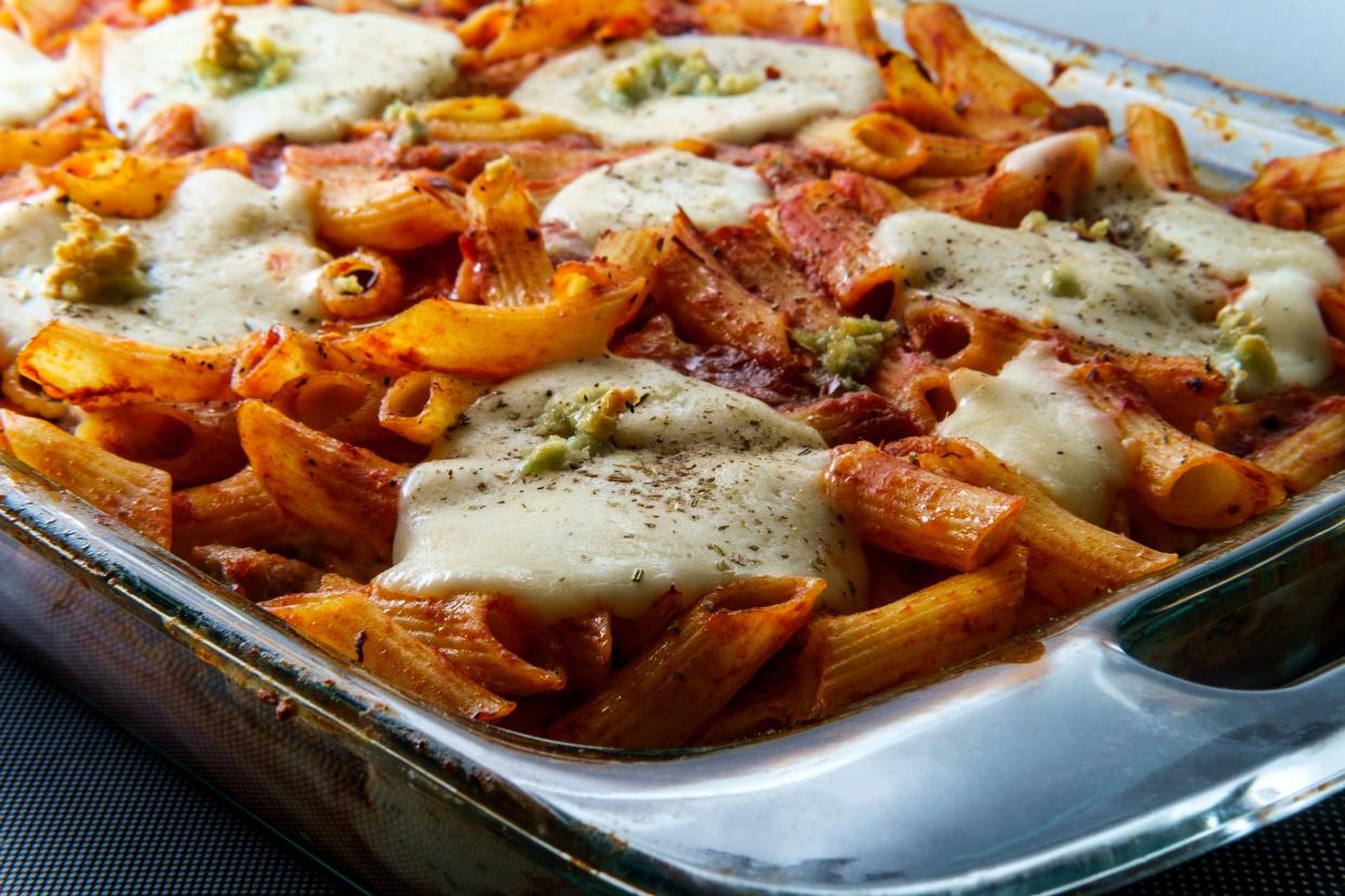 Baked ziti penne pasta casserole dinner topped with fresh mozzarella and italian seasoning