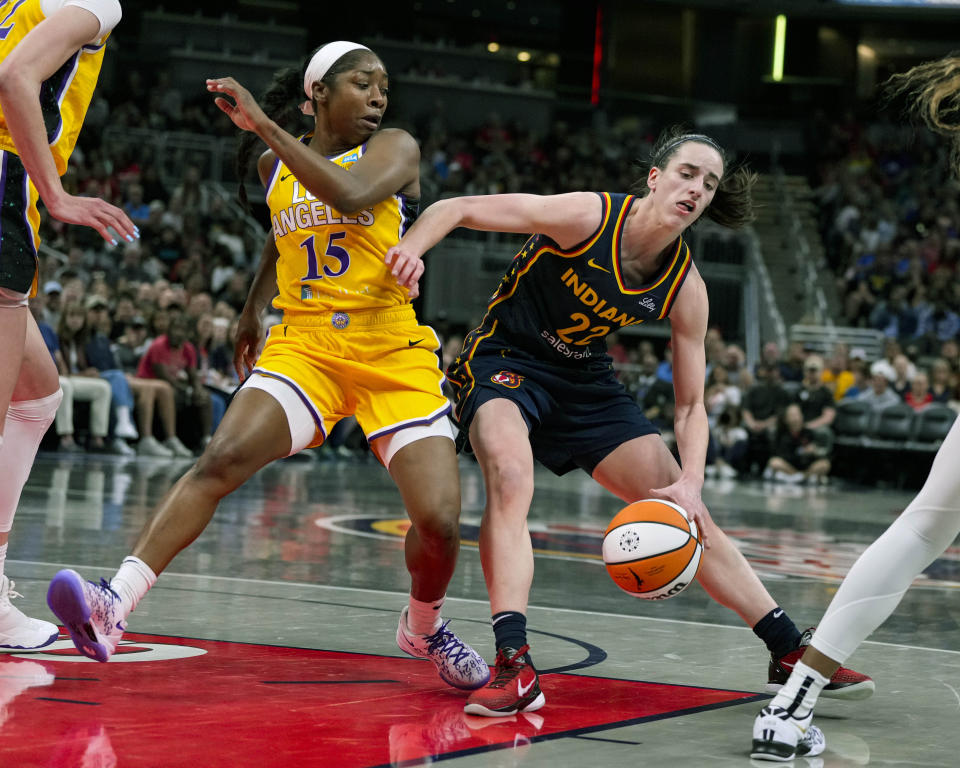 Indiana Fever guard Caitlin Clark (22) drives on Los Angeles Sparks guard Aari McDonald (15) in the first half of a WNBA basketball game in Indianapolis, Tuesday, May 28, 2024. (AP Photo/Michael Conroy)