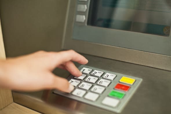 Woman using keypad on ATM