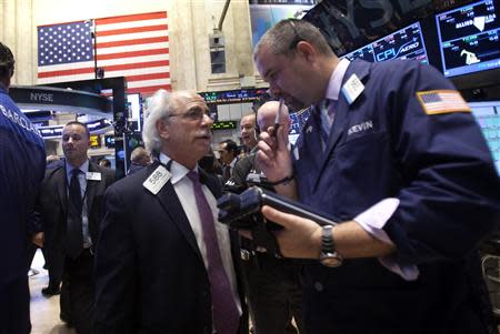 Traders speak on the floor of the New York Stock Exchange at the market open in New York, October 15, 2013. REUTERS/Carlo Allegri