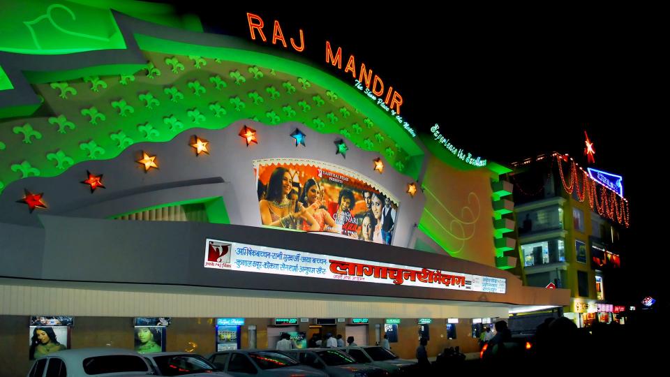 green lit movie theater raj mandir in jaipur, india, by night.