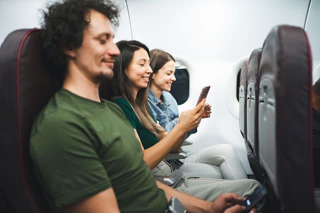 <p>Getty</p> Passengers smiling on the plane