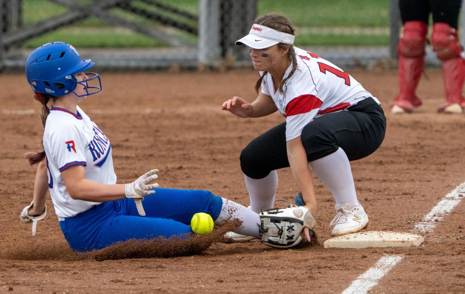 Roncalli High School's Kaitlyn Leister (3) slides safely into third as New Palestine High School's Paige Ernstes (11) guards the bag and can’t quite haul in the throw, Wednesday, May 25, 2022, at the 4A sectional softball final won by Roncalli 10-0. 