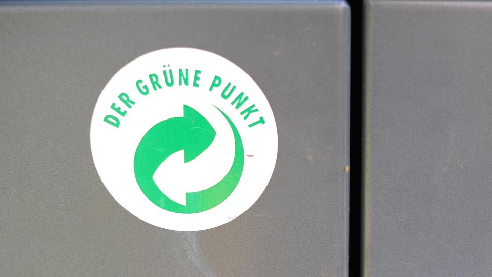 Ein Aufkleber mit dem Logo «Der Grüne Punkt» auf einem Mülleimer. Foto: Marcus Brandt