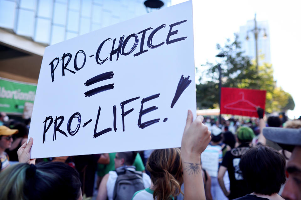 Abortion rights supporters gather, one holding a sign saying: Pro-Choice = Pro-Life!