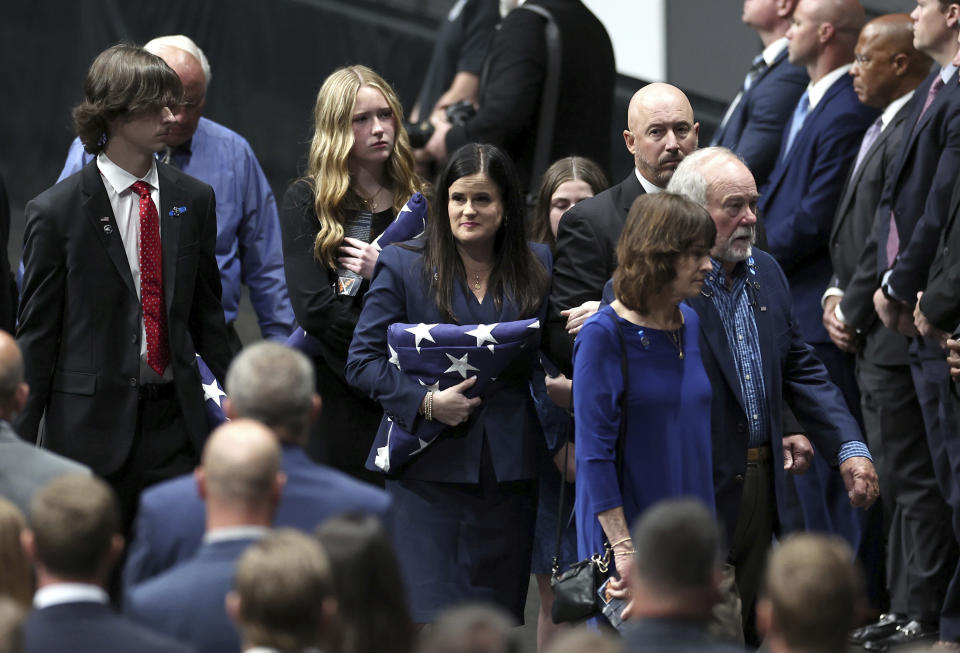 Kelly Weeks, center, the widow of slain Deputy U.S. Marshal Thomas Weeks Jr., glances over at attendees of her husband's memorial service at Bojangles Coliseum in Charlotte, N.C. on Monday, May 6, 2024. (Jeff Siner/The Charlotte Observer via AP)