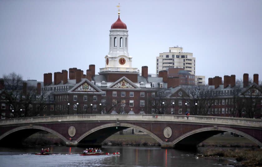 FILE - In this March 7, 2017 file photo, rowers paddle down the Charles River past the campus of Harvard University in Cambridge, Mass. A federal judge in Boston is scheduled to hear closing arguments Friday, Nov. 2, 2018, in a highly publicized lawsuit alleging that elite Harvard discriminates against Asian-Americans. Much of the spotlight has been on affluent Chinese-Americans with stellar academic scores who say the college rejects Asians in favor of lesser-qualified applicants. They say factoring in race hurts Asian-Americans. (AP Photo/Charles Krupa, File)