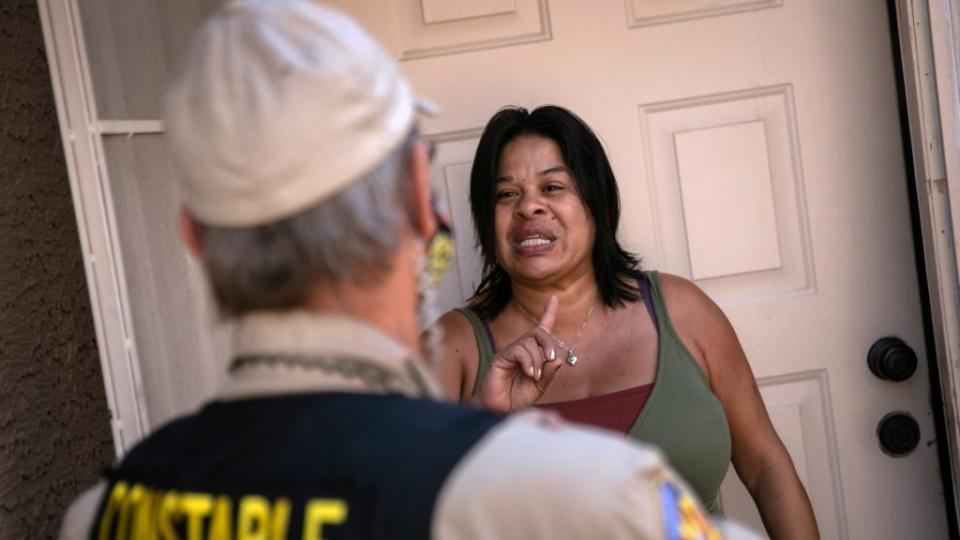 A tenant in Phoenix, Arizona speaks with a Maricopa County constable who had just arrived with an eviction order. President Joe Biden has signed an executive order extended the moratorium on evictions through March 2021 due to the coronavirus pandemic. (Photo by John Moore/Getty Images)