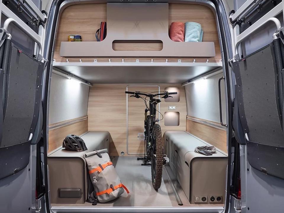 A garage in the rear of the van with a bike.
