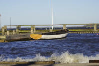 A wooden row boat, built in the Nordic clinker boat tradition, sit moored in Roskilde harbour, close to the Viking Ship Museum's boatyard. Roskilde, Denmark, Monday, Jan. 17, 2022. For thousands of years, wooden sail boats, best known for having been in use during the Viking-era, allowed the peoples of northern Europe to spread trade, influence and -- in some cases war — across the seas and rivers. In December, UNESCO, the U.N.’s culture agency, added the “clinker’ boat traditions to its list of “Intangible Cultural Heritage,” the result of the first joint nomination from the whole Nordic region. (AP Photo/James Brooks)