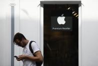 A man looks at his phone as he walks past an authorised apple reseller store in Galway, Ireland August 30, 2016. REUTERS/Clodagh Kilcoyne