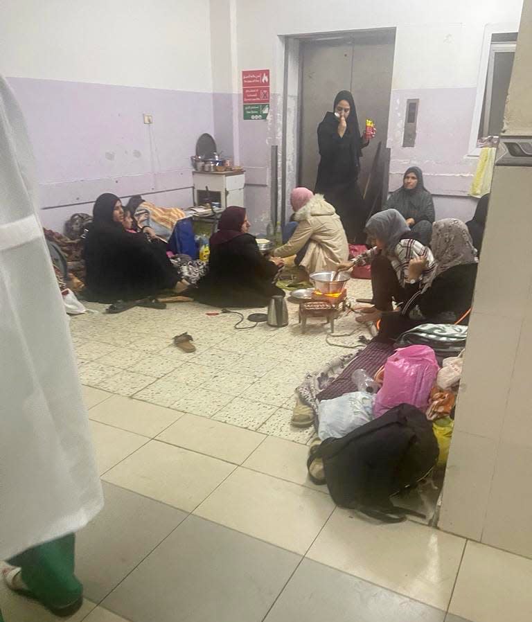 A group of women gather in a corner at Gaza's European Hospital to make food on a hot plate in late December 2023.