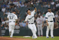 Seattle Mariners shortstop Dylan Moore, center, catches a popup hit by Houston Astros' Carlos Correa during the fifth inning of a baseball game Tuesday, July 27, 2021, in Seattle. (AP Photo/Ted S. Warren)