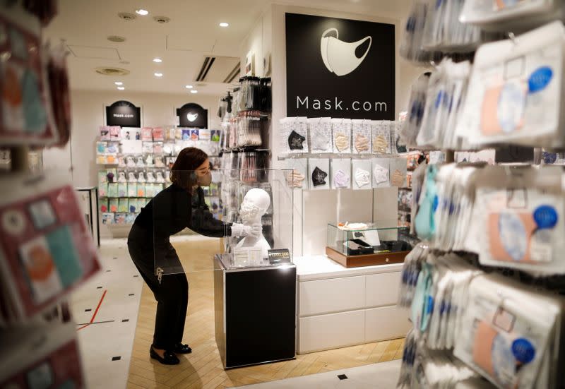 An employee of Cox Co, the operation company of the face-mask speciality shop Mask.com, displays a luxury face mask decorated with the diamond, platinum and Swarovski crystals in Tokyo