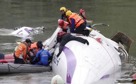 Rescuers pull a passenger out of the TransAsia Airways plane which crash landed in a river in New Taipei City, February 4, 2015. REUTERS/Pichi Chuang