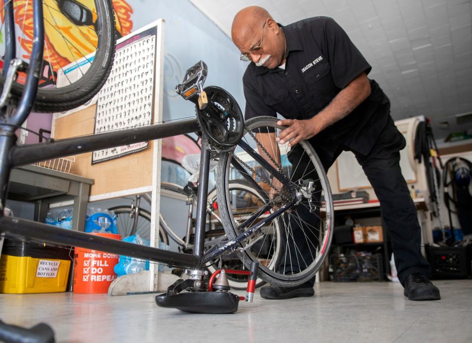 Stephen Bentley, deacon at St. John's the Evangelist Church, works on repairing a bike a the HUB (Helping Urban Bicyclists) in downtown  on Tuesday, Feb.21, 2023.