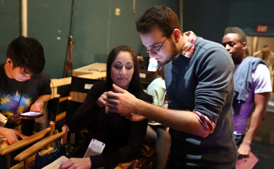 AJ Young, 23, from Chicago, right, and Jennifer Brofer, 30, from Austin, Texas, center, talk backstage during rehearsals for the 85th Academy Awards in Los Angeles, Wednesday, Feb. 20, 2013. Young and Brofer were among the six college students selected to serve as trophy presenters for The Academy Awards which will take place on Sunday, Feb. 24, 2013. (Photo by Matt Sayles/Invision/AP)