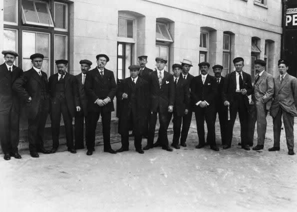 29th April 1912:  Stewards who survived the Titanic shipwreck line up outside a first class waiting room before being called in for questioning by the board of enquiry.  (Photo by Topical Press Agency/Getty Images)