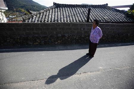 Ok Chul-soon, 82, whose husband was abducted in 1972 by North Koreans and the captain of Jeon's fishing boat, takes a walk along an alley at Nongso village in Geoje, about 470 km (292 miles) southeast of Seoul October 29, 2013. REUTERS/Kim Hong-Ji