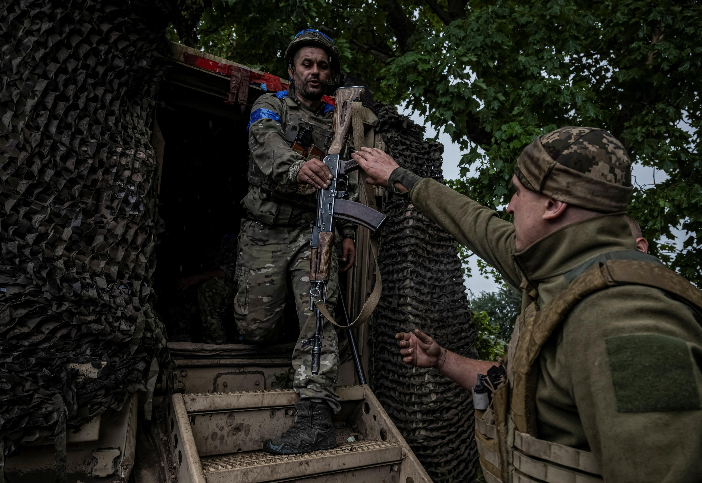 Ukrainian servicemen get out of an armored personnel carrier.