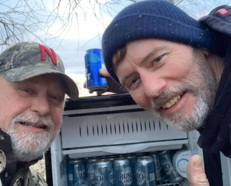 Kyle Simpson (left) and Gayland Stouffer were surprised to find a fridge full of cold beer in the middle of a field after the devastating floods in Nebraska. (Photo: Facebook)