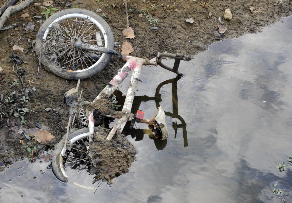 FILE- In this Sept. 26, 2019 file photo, a bicycle that was submerged in a pond lies on a dried-up bank in Helena, Ala. Scientists say more than 45 million people across 14 Southern states are now in the midst of a drought that's cracking farm soil, drying up ponds and raising the risk of wildfires. (AP Photo/Jay Reeves, File)