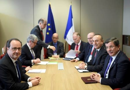 France's President Francois Hollande (L) attends a meeting with Turkish Prime Minister Ahmet Davutoglu (R) during a European Union leaders summit on migration in Brussels, Belgium, March 18, 2016. REUTERS/Stephane de Sakutin/Pool