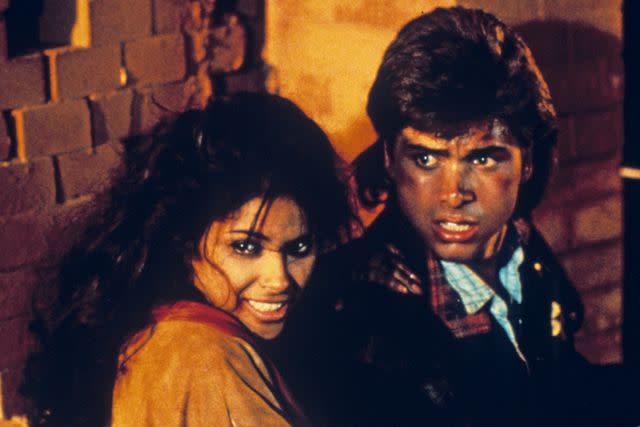 <p>Paul Entertainment / Courtesy Everett</p> (L-R) Vanity and John Stamos are pictured in 'Never Too Young to Die'.