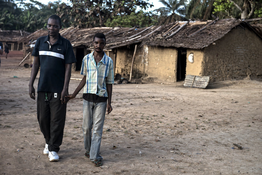 Bosumbuka walks around his village of Salambongo guided by his son who also shows symptoms of river blindness. (Photo: Neil Brandvold/DNDi)