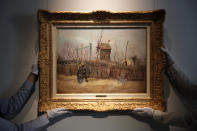 Sotheby's personnel display « Scene de rue à Montmartre » (Street scene in Montmartre), a painting by Dutch master Vincent van Gogh at Sotheby's auction house in Paris, Thursday, Feb. 25, 202. The artwork painted in 1887 is to be on public display for the first time ahead of an auction next month. It has remained in the same family collection for over 100 years, according to the auction house which did not reveal the identity of the owner. (AP Photo/Christophe Ena)