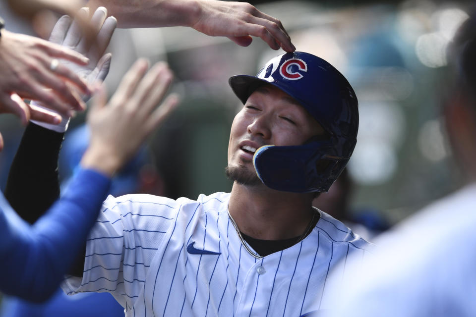 Chicago Cubs' Seiya Suzuki celebrates with teammates in the dugout after scoring on a Franmil Reyes single during the first inning of a baseball game against the Cincinnati Reds Sunday, Oct. 2, 2022, in Chicago. (AP Photo/Paul Beaty)