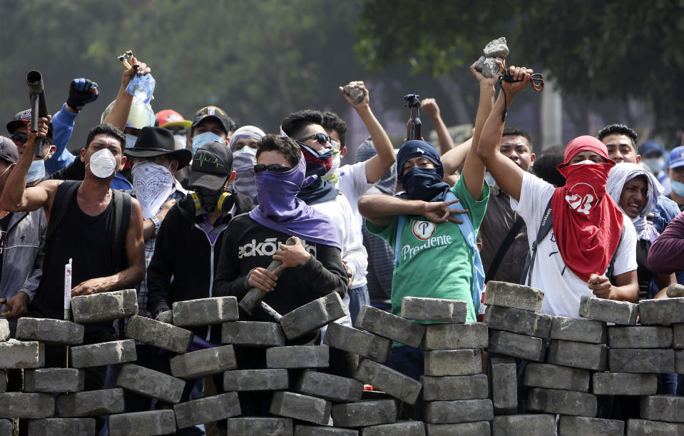 FILE - Protesters yell from behind the road block they erected as they face off with security forces near the University Politecnica de Nicaragua, UPOLI, in Managua, Nicaragua, Saturday, April 21, 2018. Nicaragua's National Assembly, controlled by President Daniel Ortega, outlawed four private universities on Wednesday, Feb. 2, 2022. Among the schools whose legal standing the assembly canceled was the UPOLI, which was a hotbed of antigovernment protests in 2018. (AP Photo/Alfredo Zuniga, File)