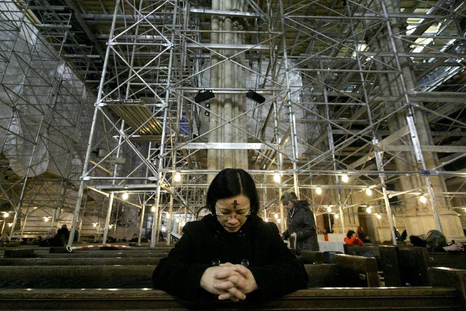 A woman prays at St. Patrick's Cathedral, Wednesday, March 5, 2014 in New York. Some Protestant, and all Catholic churches, distribute ashes on the forehead as a sign of repentance and renewal on Ash Wednesday as the 40-day season leading to Easter begins. The cathedral is filled with scaffolding as it is undergoing renovations. (AP Photo/Mark Lennihan)