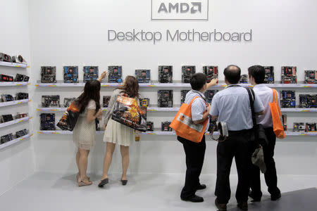 FILE PHOTO: Visitors look at motherboards being displayed at the AMD booth during the 2012 Computex exhibition at the TWTC Nangang exhibition hall in Taipei June 6, 2012. REUTERS/Yi-ting Chung/File Photo