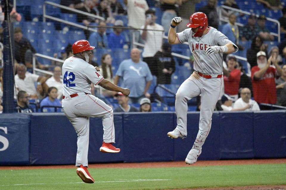 Los Angeles Angels' Mike Trout, right, celebrates with third base coach Eric Young Sr. after hitting a two-run home run off Tampa Bay Rays reliever Phil Maton during the eighth inning of a baseball game Monday, April 15, 2024, in St. Petersburg, Fla. (AP Photo/Steve Nesius)