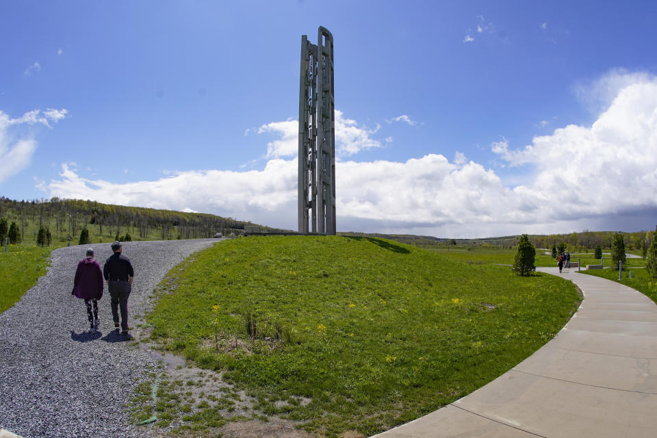 A couple visiting the Flight 93 National Memorial walk the path to the "Tower of Voices," Saturday, May 8, 2021, in Shanksville, Pa. The tower containing 40 wind chimes honors the 40 people that died in the crash of Flight 93 in the terrorist attack of Sept. 11, 2001. (AP Photo/Keith Srakocic)