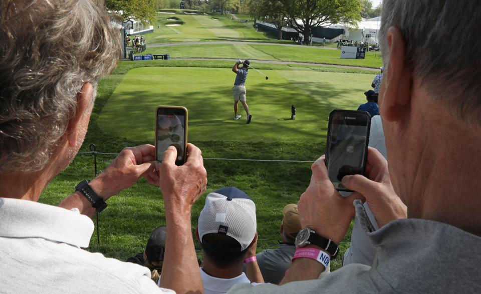 Fans take photos with their smart phones as Bryson DeChambeau tees off on the 14th hole during his practice round at the PGA Championship at Oak Hill Country Club Monday, May 15, 2023. 