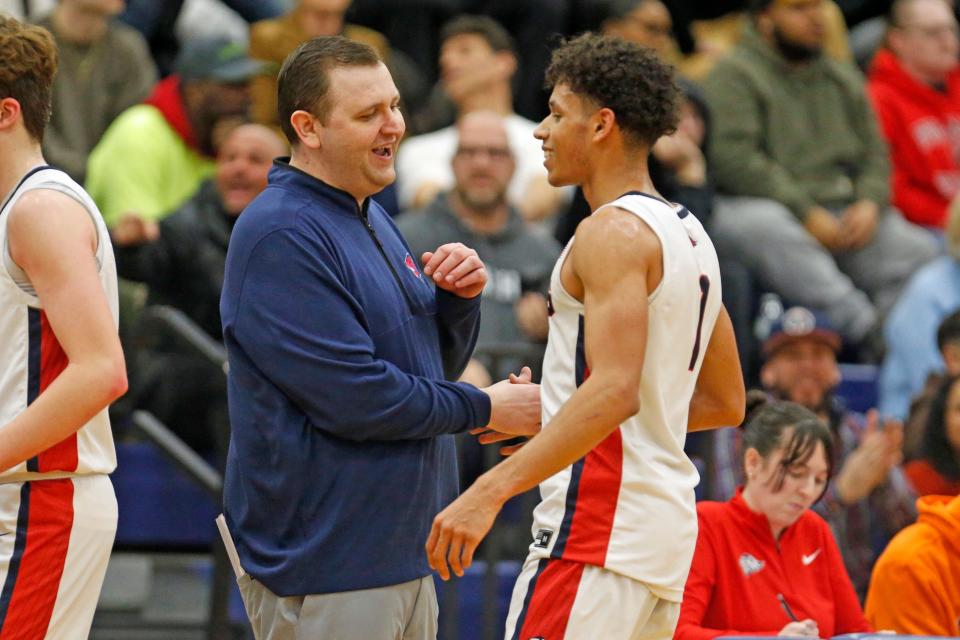 Lincoln coach Jeremy Wilner congratulates senior Wayne McNamara after his 30-point performance in the Lions' win over Tolman Thursday in Cumberland's 50th annual Holiday Roadshow.