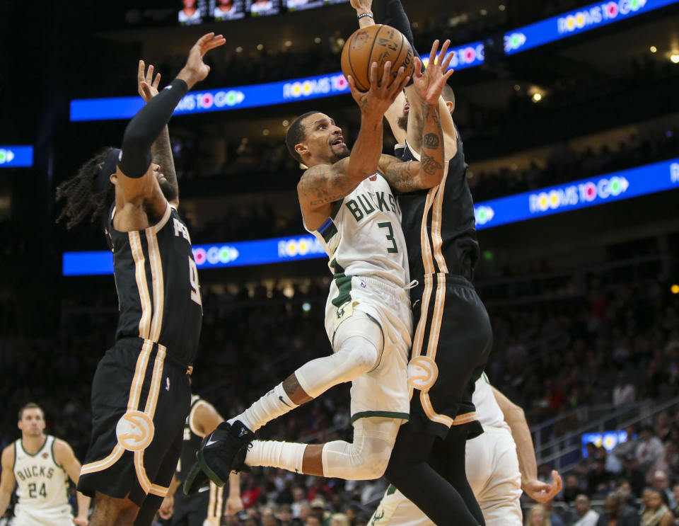 Milwaukee Bucks guard George Hill (3) shoots past Atlanta Hawks guard DeAndre' Bembry (95) and center Alex Len (25) in the first half of an NBA basketball game, Wednesday, Nov. 20, 2019, in Atlanta. (AP Photo/Brett Davis)