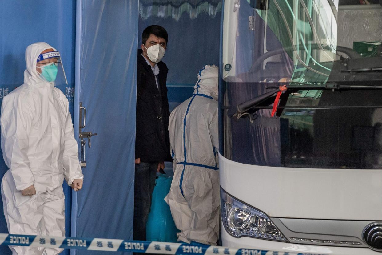 A member of the World Health Organization (WHO) team investigating the origins of the pandemic boards a bus following their arrival in Wuhan  (AFP via Getty Images)