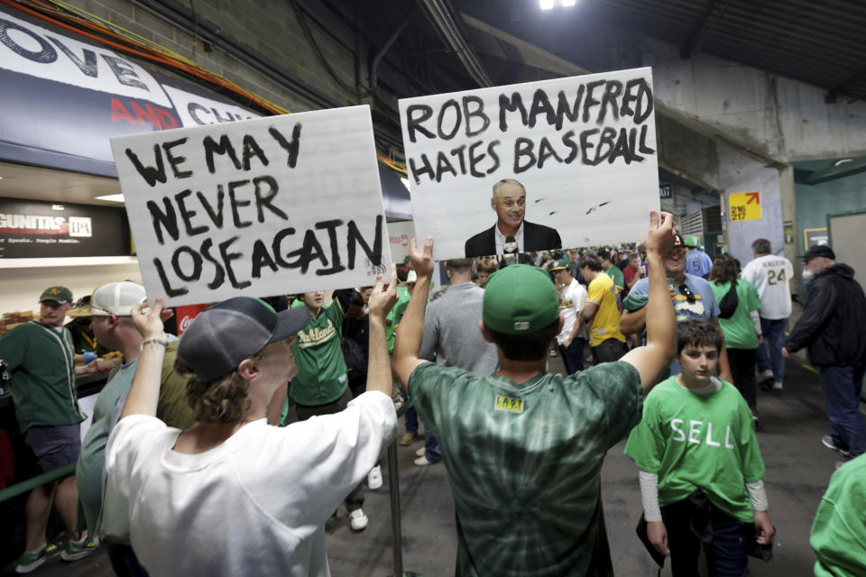 Fans hold signs inside Oakland Coliseum to protest the Oakland Athletics' planned move to Las Vegas, before a baseball game between the Athletics and the Tampa Bay Rays in Oakland, Calif., Tuesday, June 13, 2023. (AP Photo/Jed Jacobsohn)