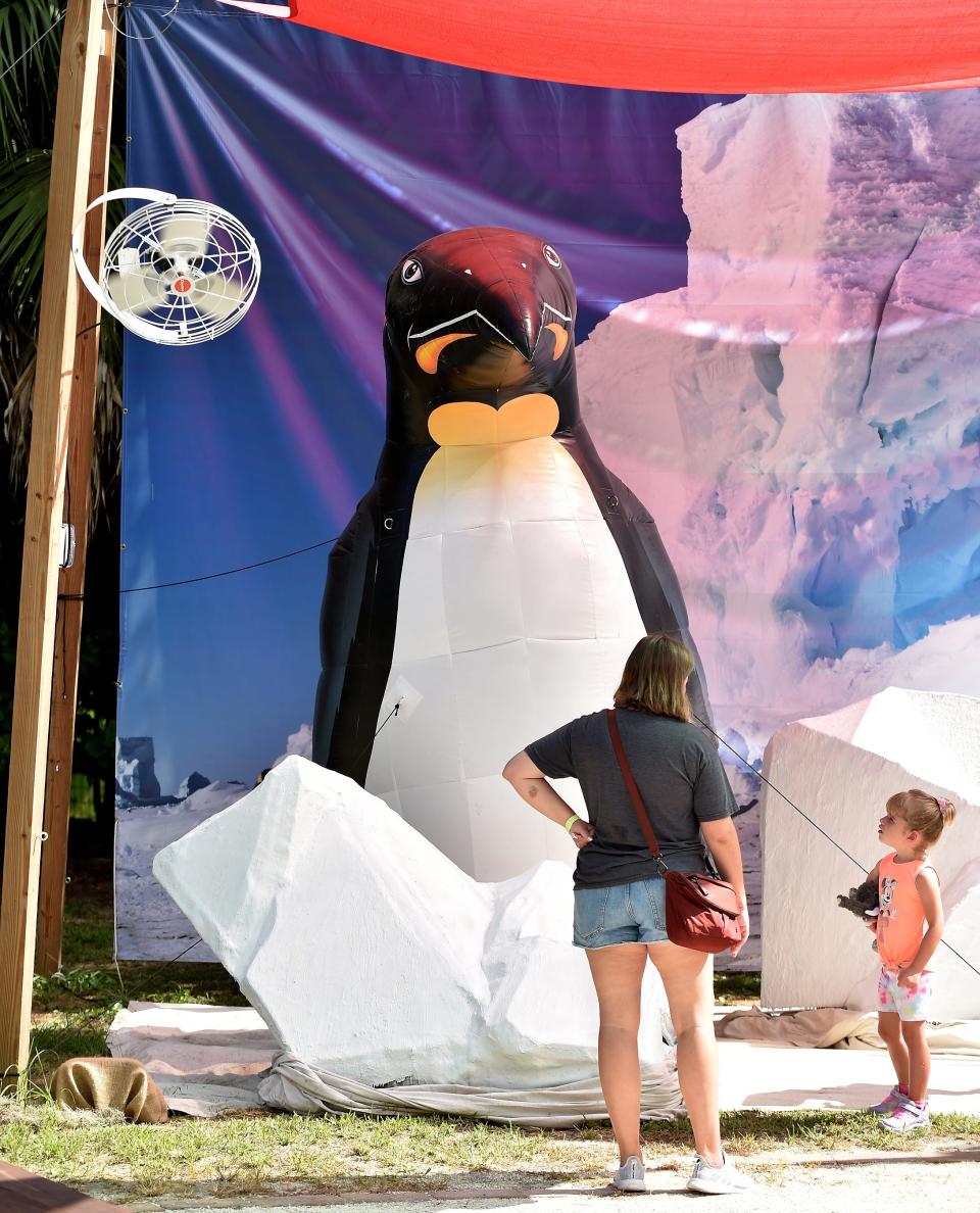 A giant Emperor Penguin inflatable towers over guests at Jacksonville Zoo and Gardens' new Colossal Creatures exhibit.