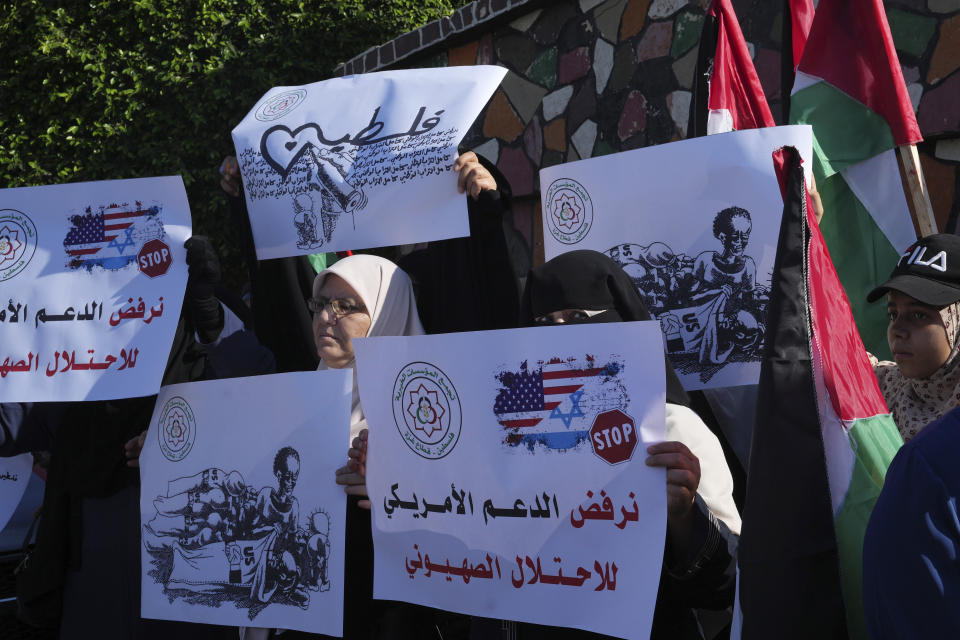 Women wave their national flags while holding placards in Arabic that reads "we reject the U.S. support to the Zionist occupation", and the second placard in the back and the left reads “Palestine," during a protest against U.S. President Joe Biden's visit to the region, at the Unknown Soldier square in Gaza City, Thursday, July 14, 2022. (AP Photo/Adel Hana)