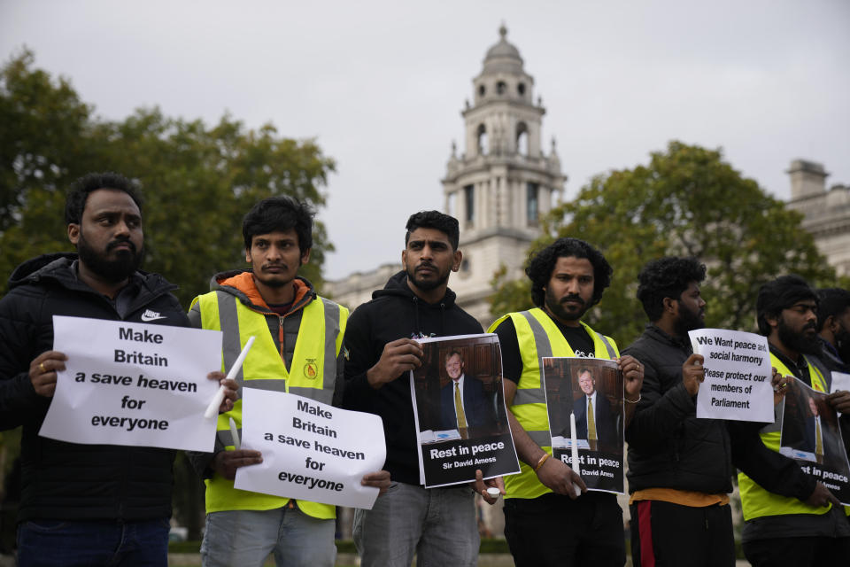 People from the Freedom Hunters for Tamils organisation hold signs and pictures in memory of British Member of Parliament David Amess on Parliament Square, opposite the Houses of Parliament in London, Monday, Oct. 18, 2021. British lawmaker David Amess was killed on Friday during a meeting with constituents at the Belfairs Methodist church, in Leigh-on-Sea, Essex, England. (AP Photo/Matt Dunham)