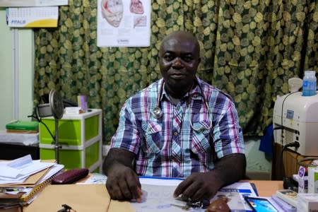 Dr. Frederick Sarpong sits at a desk at the El-Shiva clinic in Bawdie