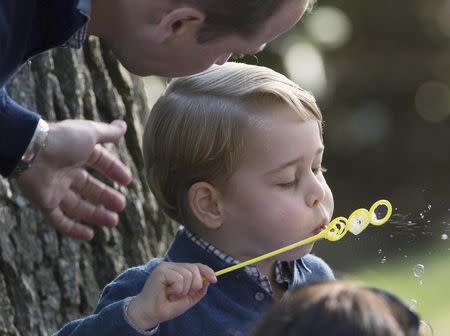 The Duke Cambridge looks on as his son Prince George blows bubbles during a children's party at Government House in Victoria, British Columbia, Canada September 29, 2016. REUTERS/Jonathan Hayward/Pool