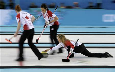 Canada's lead Dawn McEwen (L) and second Jill Officer prepare to sweep as skip Jennifer Jones (R) delivers a stone in their women's gold medal curling game against Sweden at the Ice Cube Curling Centre during the Sochi 2014 Winter Olympics February 20, 2014. REUTERS/Marko Djurica