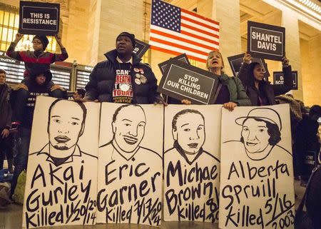 Activists protesting against police brutality hold placards with the names of some 150 people who they said were "killed or brutalized" by the police, during a demonstration in Grand Central Terminal in New York January 5, 2015. REUTERS/ Elizabeth Shafiroff